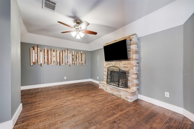 unfurnished living room featuring a fireplace, wood-type flooring, and ceiling fan