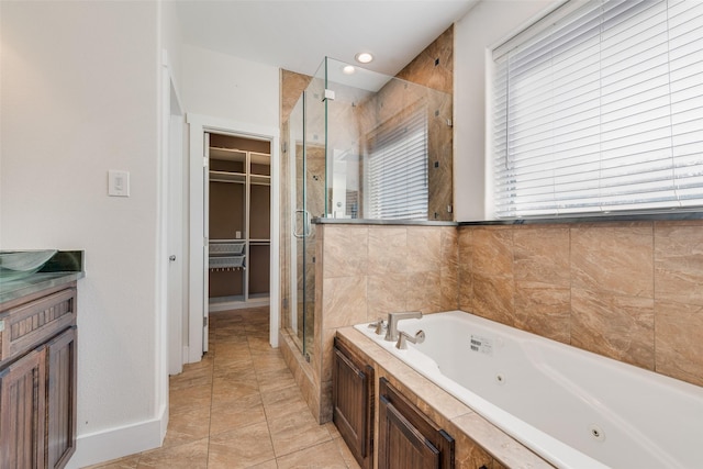 bathroom featuring tile patterned flooring, vanity, and separate shower and tub