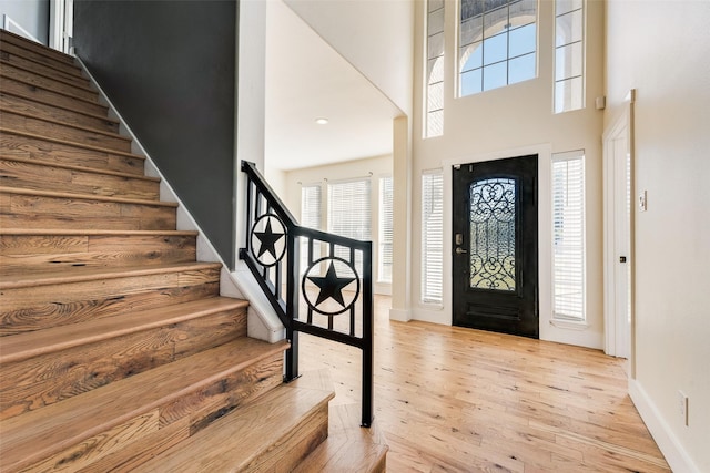 foyer entrance with a high ceiling and light hardwood / wood-style flooring