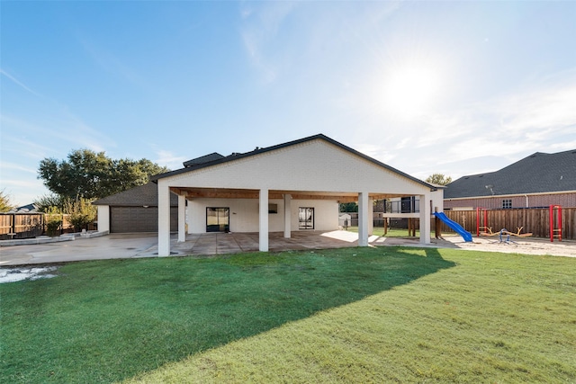 rear view of property featuring a playground, a patio area, and a yard