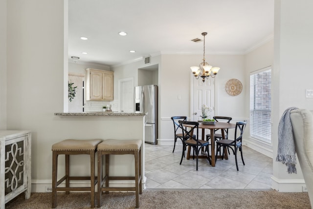 dining room with a chandelier, light tile patterned floors, and ornamental molding