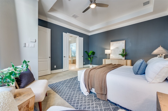 bedroom featuring ensuite bathroom, ceiling fan, crown molding, and a tray ceiling