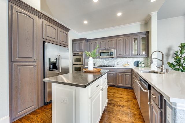 kitchen featuring ornamental molding, sink, dark wood-type flooring, and appliances with stainless steel finishes