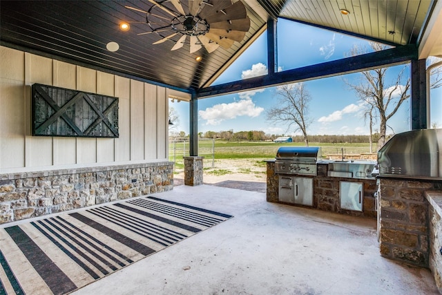 view of patio with area for grilling, ceiling fan, and a rural view