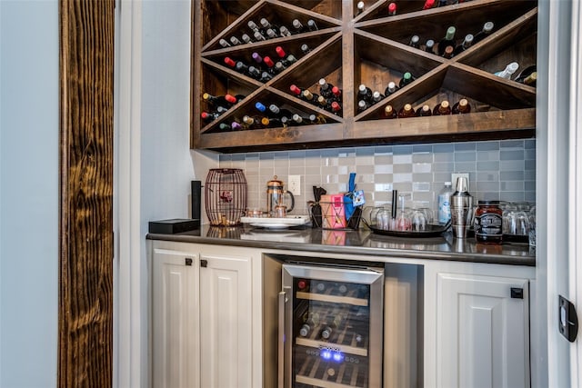 bar with backsplash, wine cooler, and white cabinetry