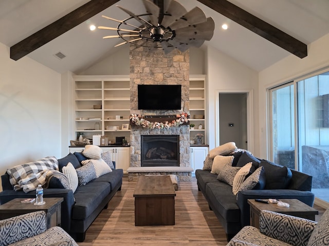 living room with a fireplace, wood-type flooring, vaulted ceiling with beams, and ceiling fan