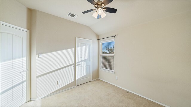 carpeted spare room with ceiling fan and lofted ceiling