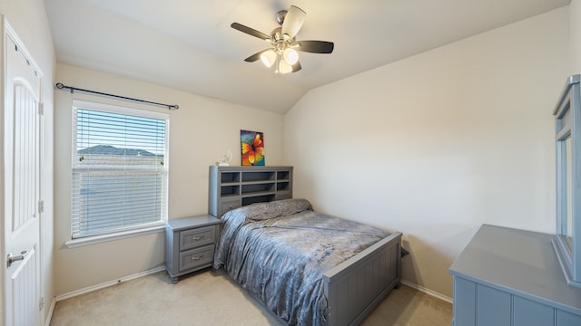 bedroom featuring ceiling fan, light colored carpet, and vaulted ceiling