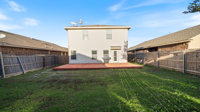 rear view of property featuring a yard and a wooden deck