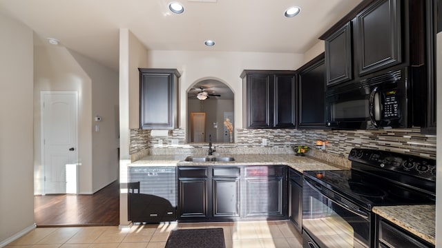 kitchen featuring black appliances, light hardwood / wood-style floors, light stone countertops, and sink