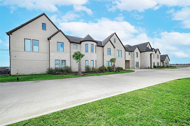 view of front of property with cooling unit and a front yard