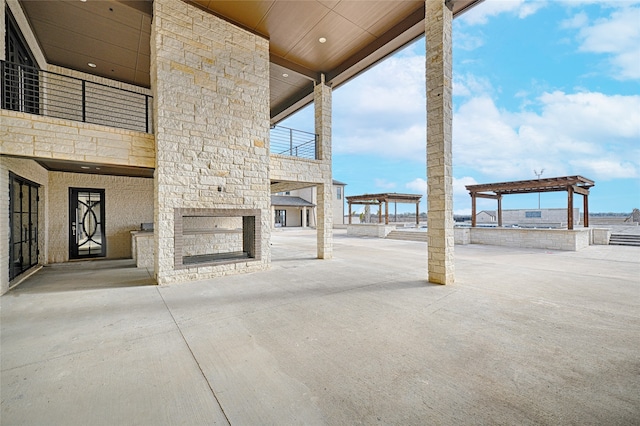 view of patio / terrace featuring a pergola and exterior fireplace