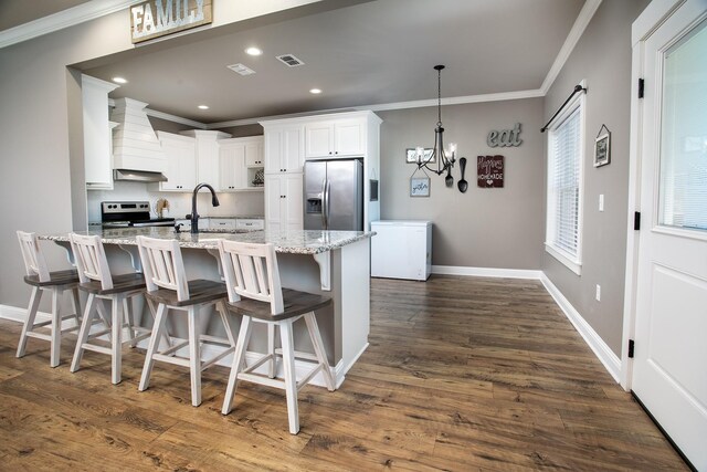 kitchen featuring white cabinetry, sink, light stone countertops, custom range hood, and appliances with stainless steel finishes