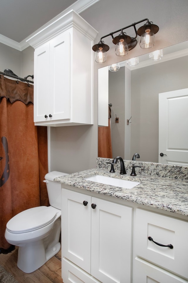 bathroom with wood-type flooring, vanity, toilet, and crown molding