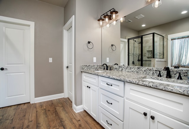 bathroom featuring vanity, a shower with shower door, and hardwood / wood-style flooring