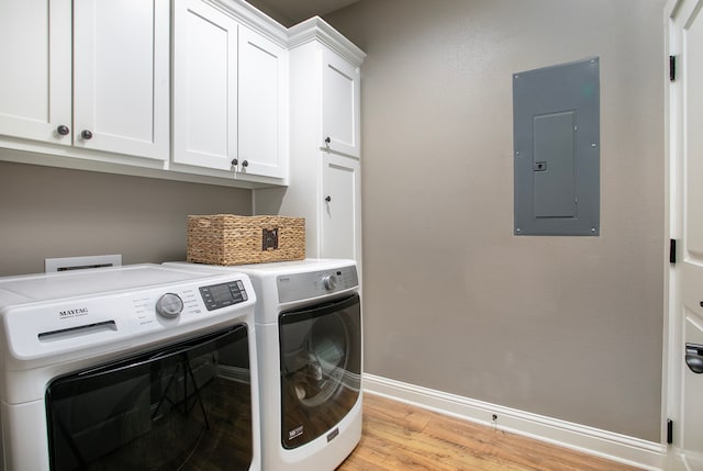 laundry area with light hardwood / wood-style floors, cabinets, separate washer and dryer, and electric panel