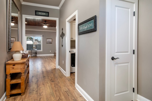 corridor featuring light wood-type flooring, wooden ceiling, and ornamental molding