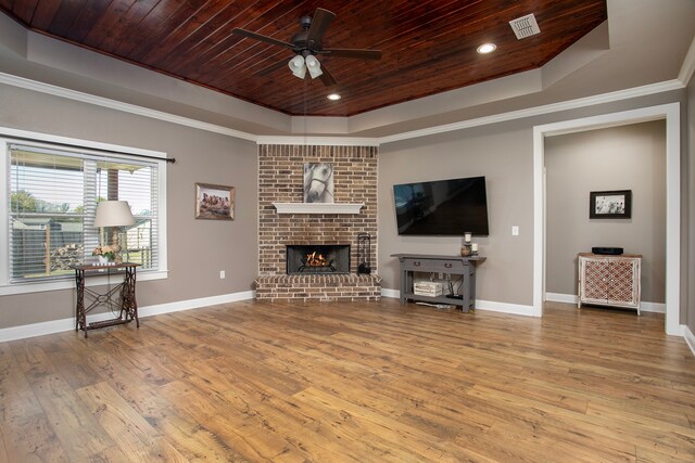 living room featuring a raised ceiling, ceiling fan, a fireplace, and wooden ceiling