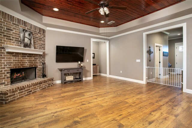 living room featuring a tray ceiling, crown molding, ceiling fan, and wooden ceiling