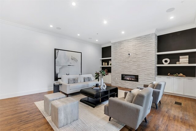 dining area featuring light hardwood / wood-style flooring, built in shelves, a stone fireplace, and an inviting chandelier