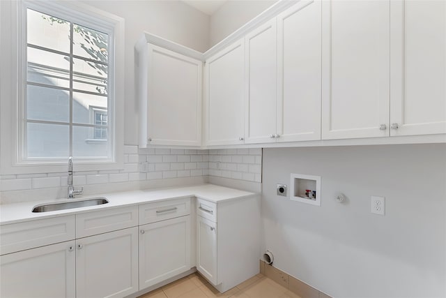 clothes washing area with cabinet space, hookup for a gas dryer, a sink, hookup for a washing machine, and electric dryer hookup