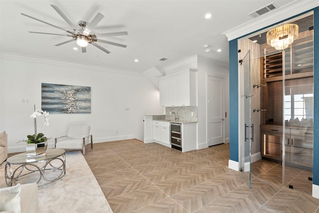 living area with ornamental molding, beverage cooler, visible vents, and baseboards