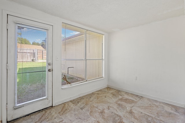 doorway to outside with a textured ceiling