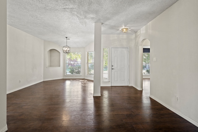 entrance foyer with a textured ceiling, dark hardwood / wood-style floors, and an inviting chandelier