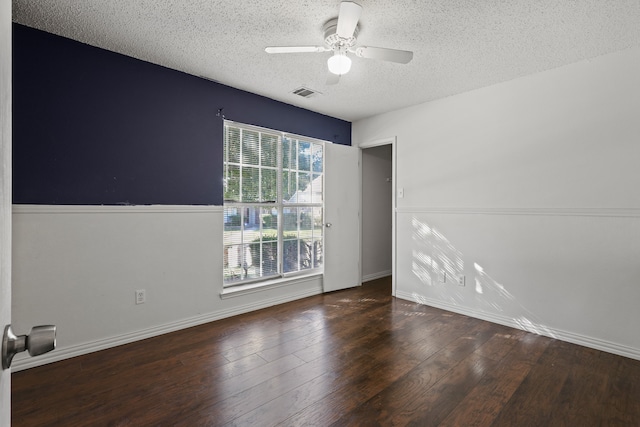 empty room featuring a textured ceiling, ceiling fan, and dark wood-type flooring