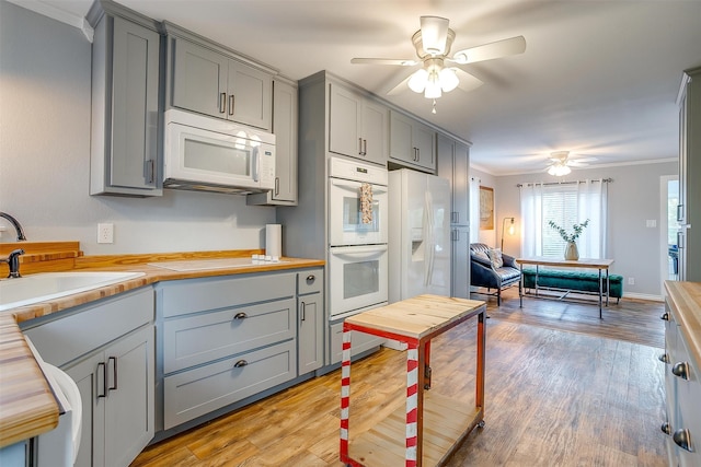 kitchen featuring gray cabinetry, white appliances, ornamental molding, butcher block countertops, and light hardwood / wood-style floors