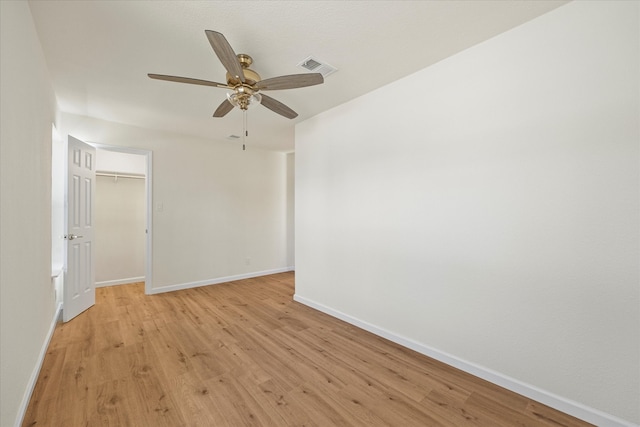 empty room with ceiling fan and light hardwood / wood-style flooring