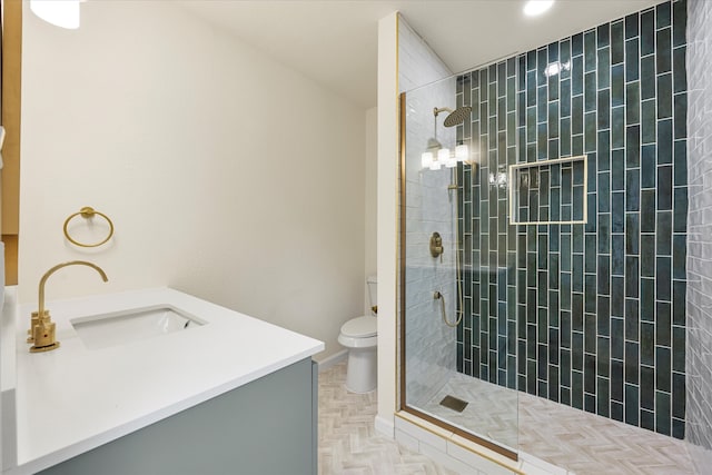 bathroom with vanity, toilet, parquet floors, and a tile shower