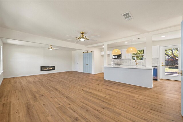 unfurnished living room with ceiling fan, light hardwood / wood-style flooring, and french doors