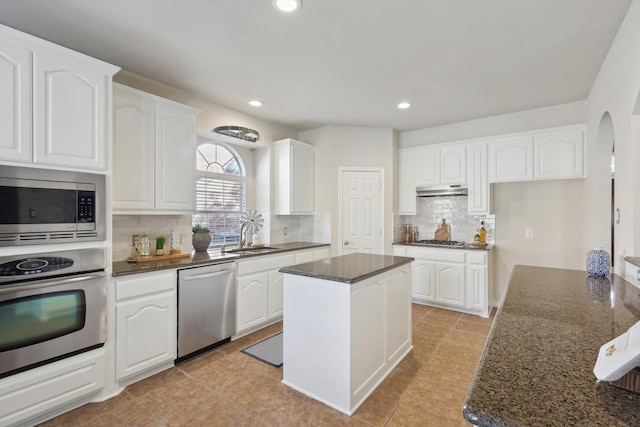 kitchen featuring white cabinets, a center island, dark stone countertops, and appliances with stainless steel finishes