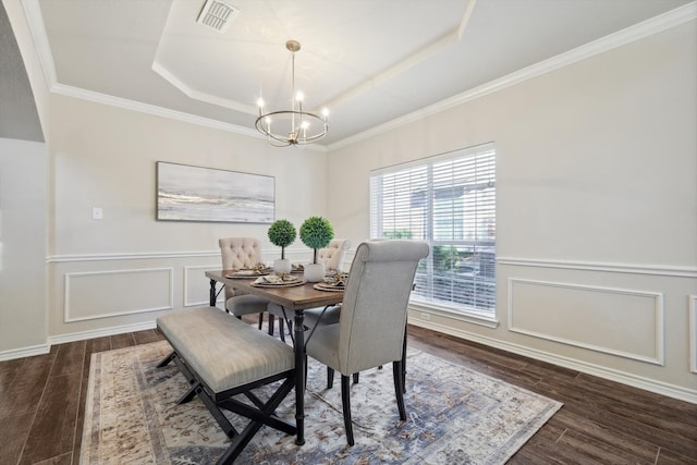 dining space with a chandelier, dark hardwood / wood-style flooring, a raised ceiling, and crown molding