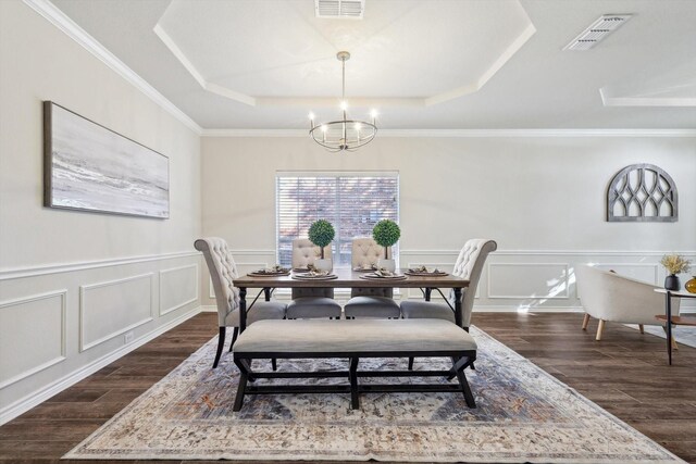 dining room featuring a tray ceiling, ornamental molding, dark hardwood / wood-style floors, and a notable chandelier