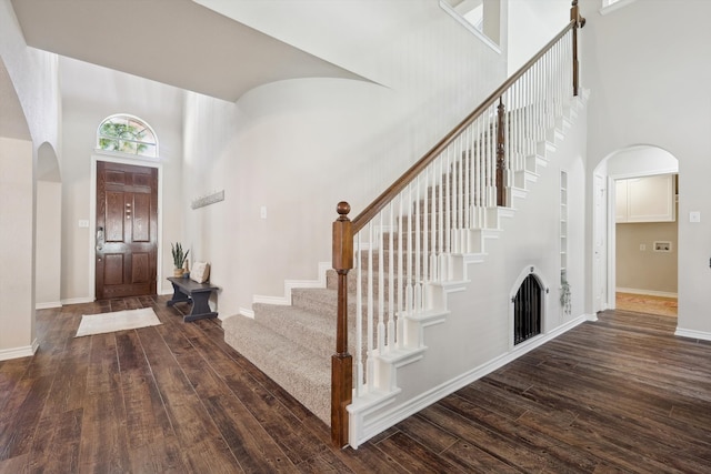 entrance foyer featuring a towering ceiling and dark hardwood / wood-style floors