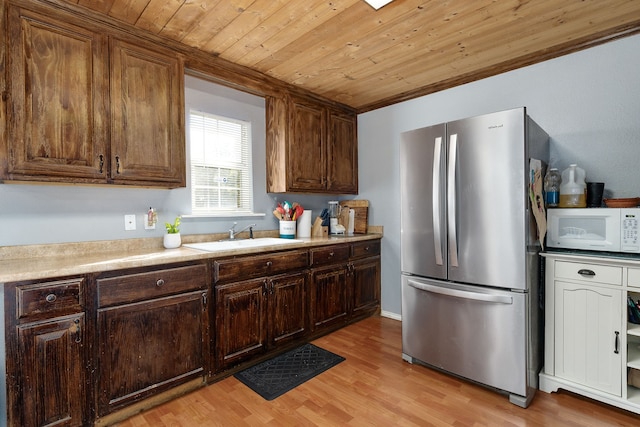 kitchen with sink, stainless steel fridge, dark brown cabinets, light hardwood / wood-style floors, and wood ceiling