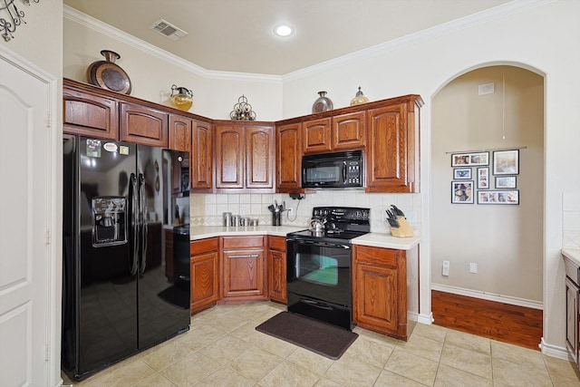 kitchen featuring black appliances, light hardwood / wood-style floors, crown molding, and tasteful backsplash