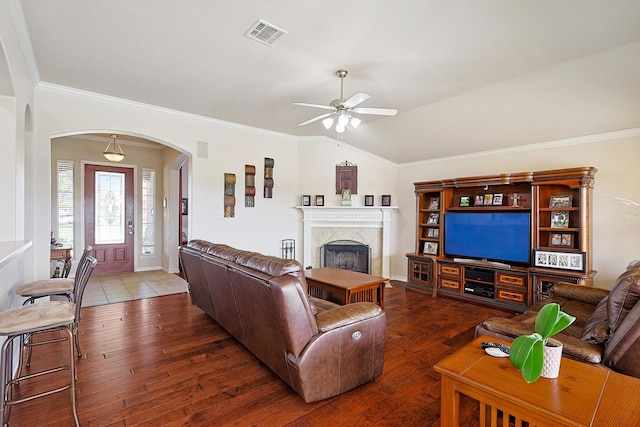 living room featuring dark hardwood / wood-style floors, ceiling fan, lofted ceiling, and a tile fireplace