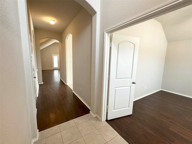 hall featuring light hardwood / wood-style floors and lofted ceiling