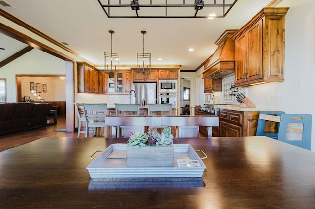 kitchen with brown cabinets, a kitchen island with sink, visible vents, and stainless steel appliances