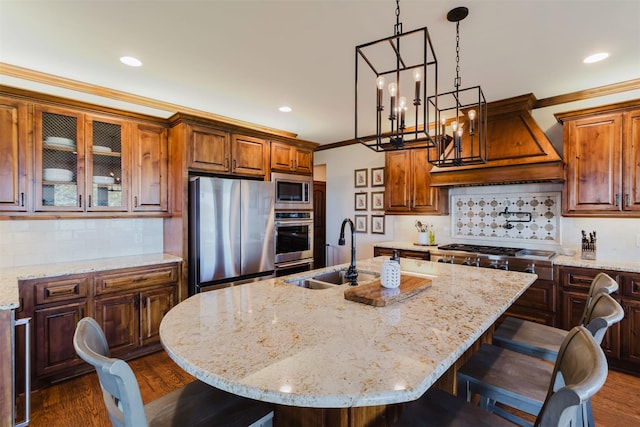 kitchen featuring ornamental molding, a breakfast bar, custom exhaust hood, stainless steel appliances, and a sink