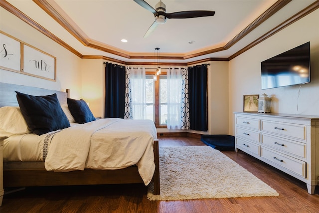 bedroom featuring a raised ceiling, dark wood finished floors, and crown molding