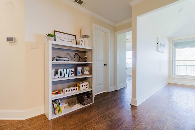 hallway with dark wood-style floors, visible vents, crown molding, and baseboards