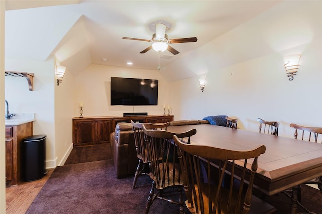 dining space featuring a ceiling fan, baseboards, wood finished floors, and lofted ceiling
