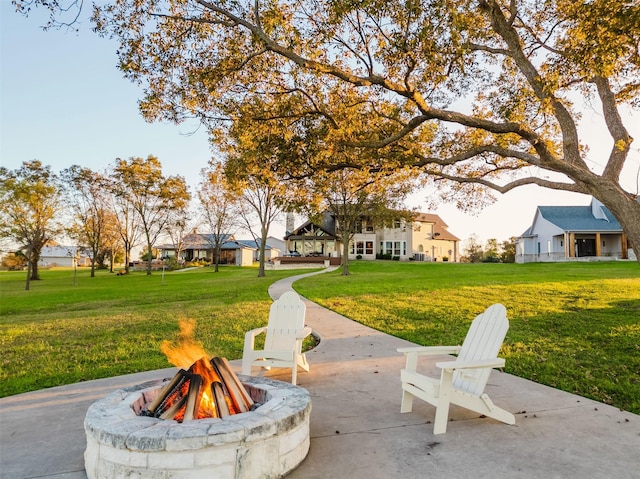 view of property's community with a yard, a patio, and a fire pit