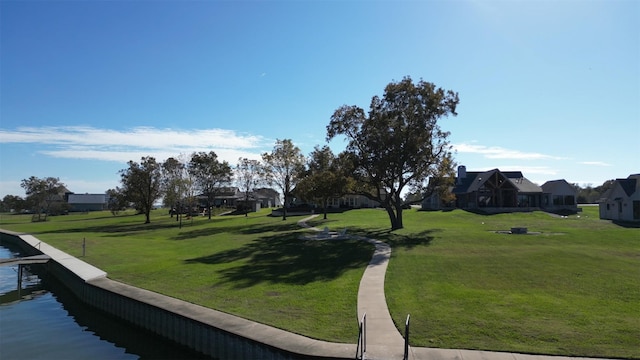 view of home's community with a water view, a residential view, and a yard