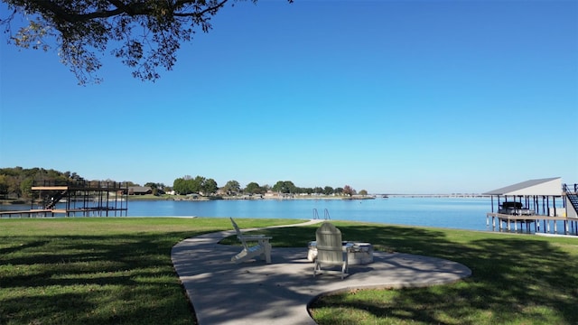 view of community featuring a boat dock, a water view, and a yard