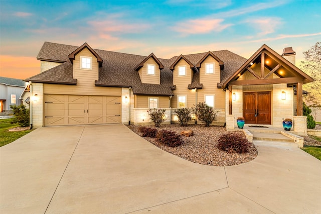 view of front of house with stone siding, roof with shingles, driveway, and an attached garage